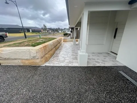 Sandstone block garden wall beside a new home entrance
