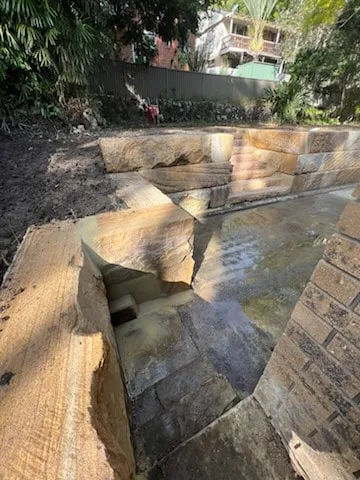Sandstone retaining wall and drainage channel on a sloping block