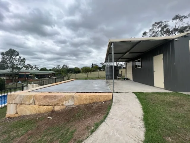 Sandstone block edging along a new driveway and lawn