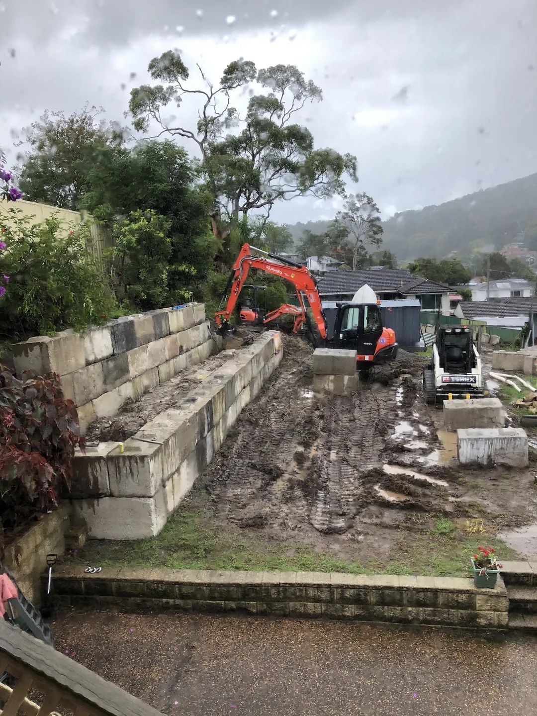 Sandstone block retaining wall being built on a sloping site